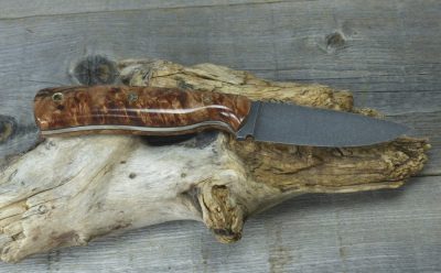 Spalted maple EDC knife displayed on driftwood