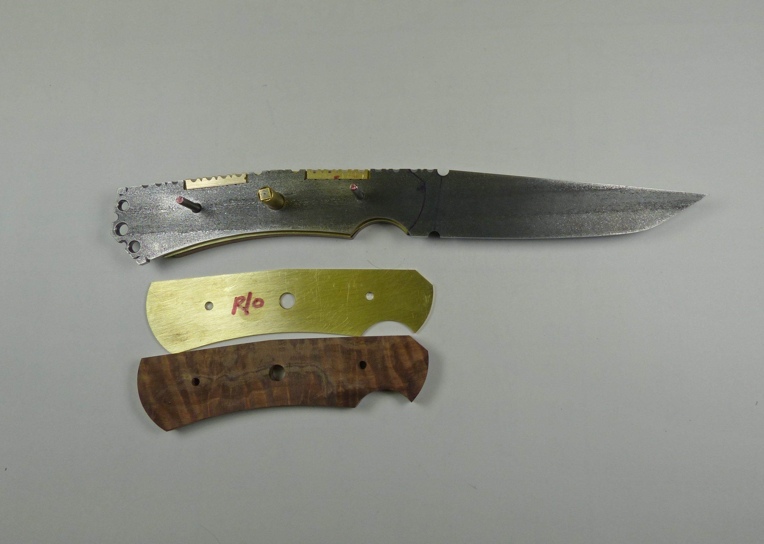 Knife blade with brass and wood handle pieces