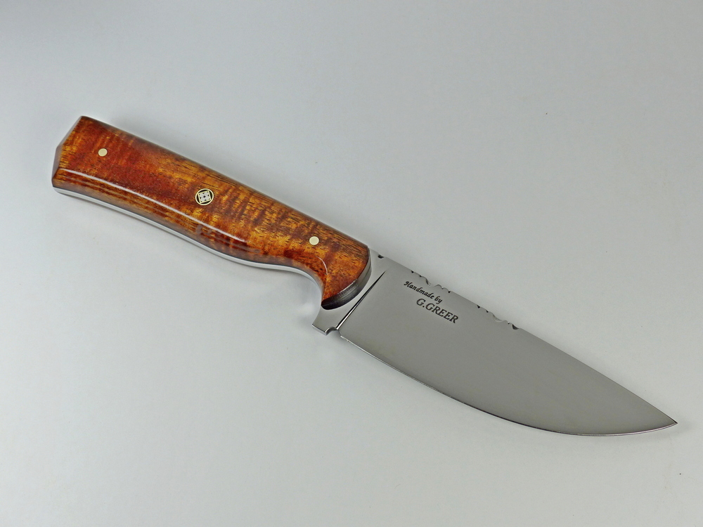 Spalted maple EDC knife displayed on driftwood