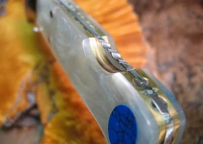 Close up of pearl polymer handle with turquoise inlay