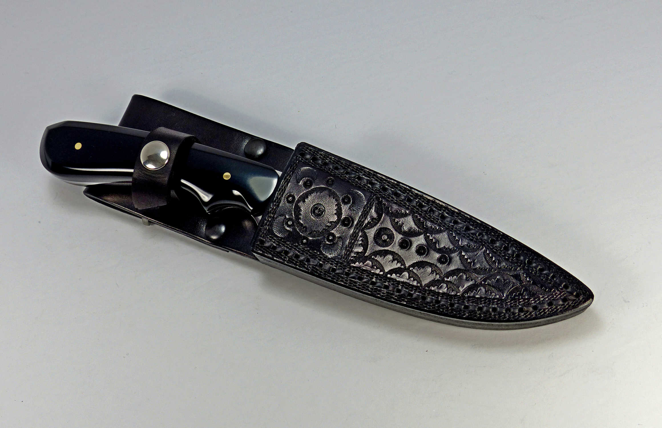 Black Paper Micarta knife inside black custom made leather sheath