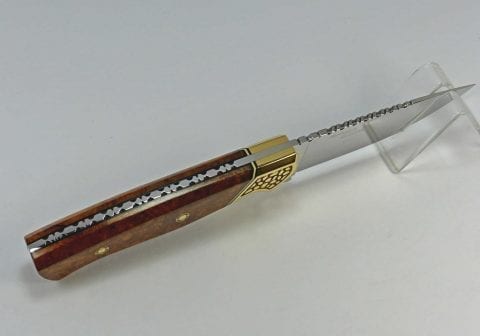 Art knife showing intricate tang filework surrounded by black tang liners