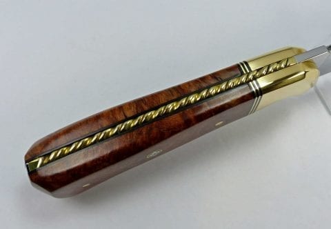 Elaborate inlaid brass rope filework surrounded by black tang liners set inside gorgeous brown knife handle