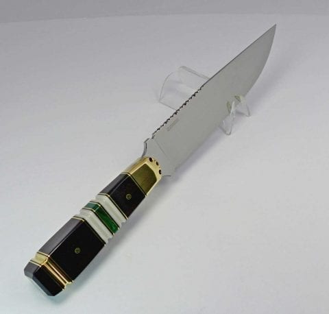 Long-bladed knife with handle made from black wood and bands of white, green and brass