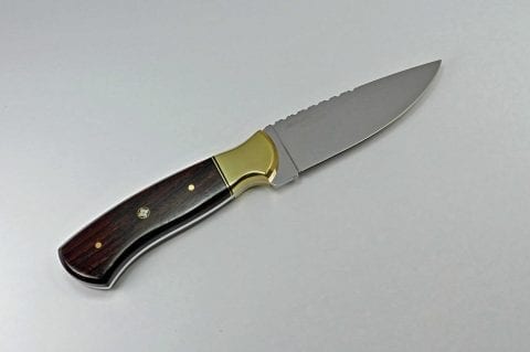 Fixed blade brown hunting knife with brass embellishments
