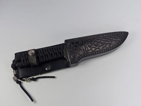 Black paracord knife inside black sheath