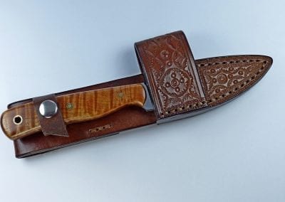 Brown colored EDC knife inserted inside leather cross draw sheath