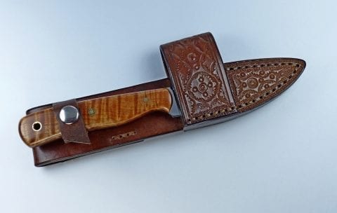 Brown colored EDC knife inserted inside leather cross draw sheath