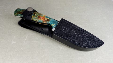 Vibrantly colored hunting knife inside black sheath